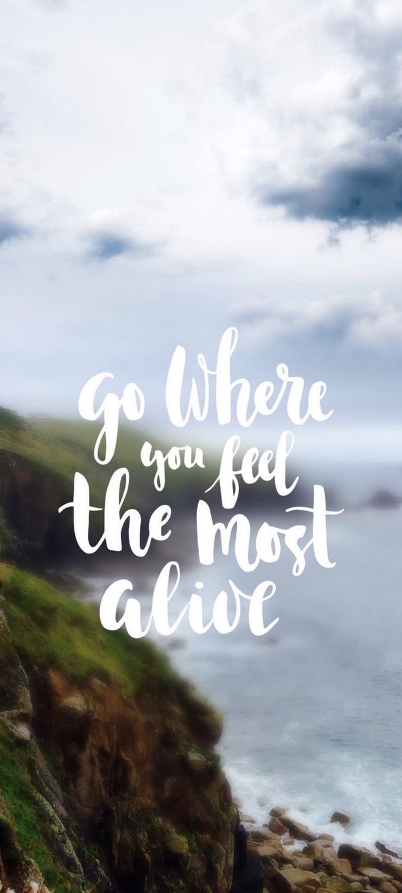 Coastal cliff overlooking blue ocean waves with white script text reading go where you feel the most alive.