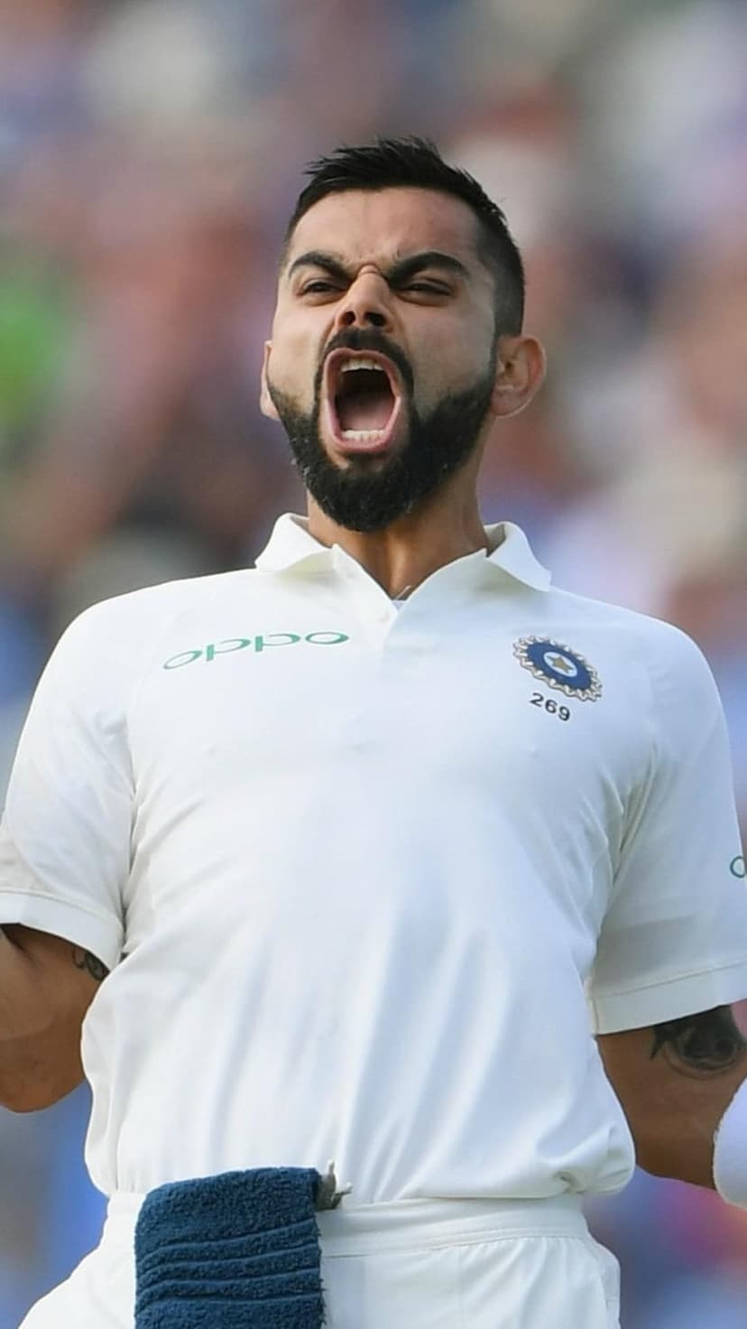Virat Kohli shouts in celebration while wearing a white Indian cricket jersey with the team crest and Oppo logo.