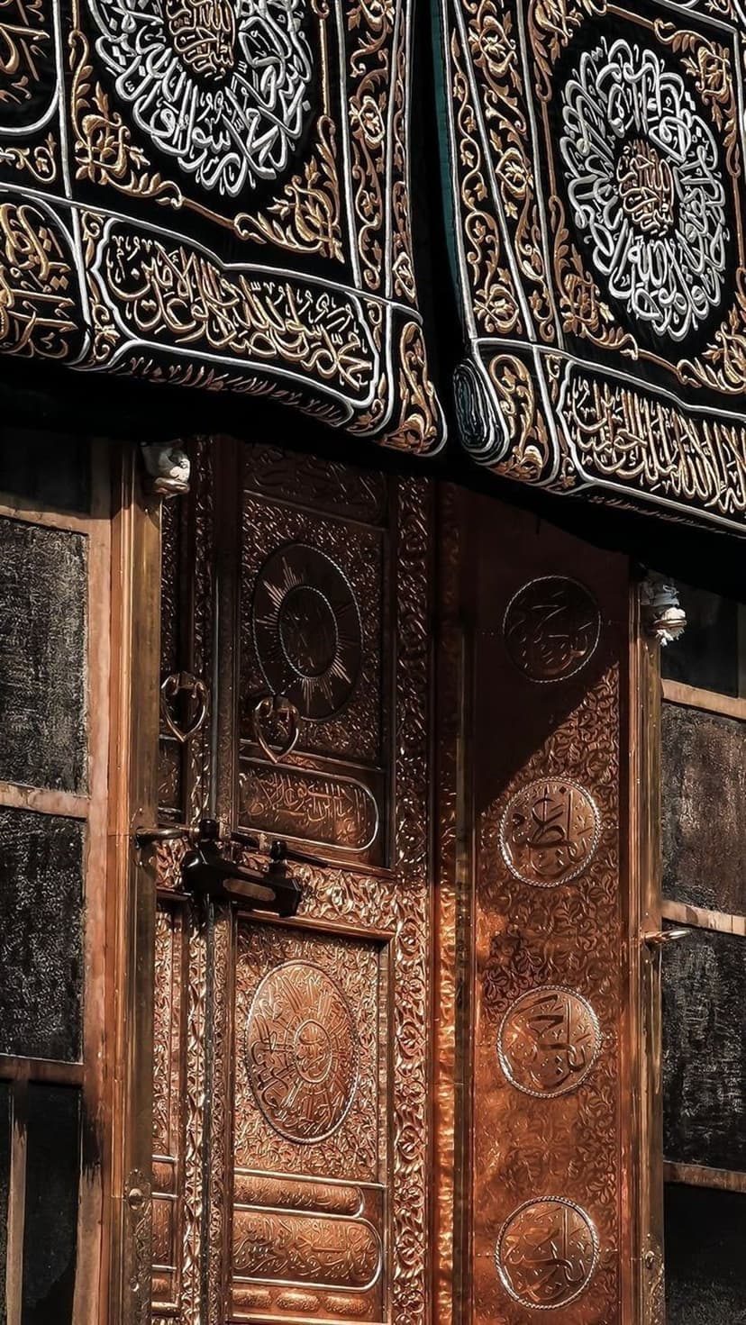 Ornate golden door of the Kaaba featuring intricate Islamic calligraphy and geometric metalwork patterns.
