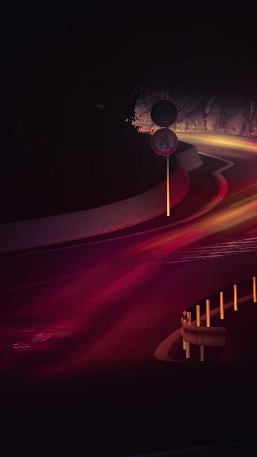 Red and yellow light trails streak through a dark highway tunnel, creating a sense of speed and motion at night.