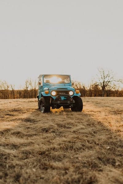 Vintage Blue Toyota Land Cruiser in Golden Hour Field