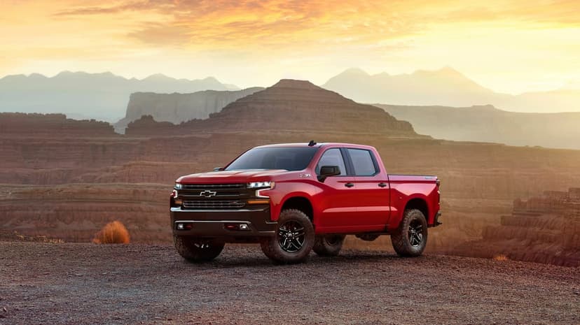 Red Chevy Silverado Z71 truck on a rocky desert overlook with golden sunset sky and canyon vistas.