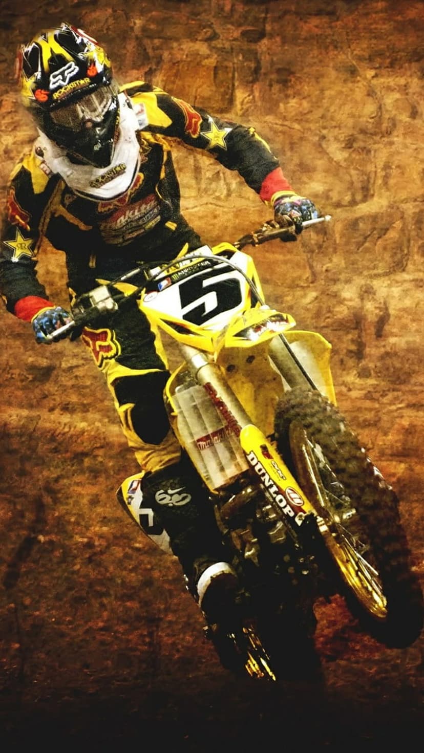 Motocross rider in yellow and black gear leans a dirt bike into a sharp turn against an earthy brown background.