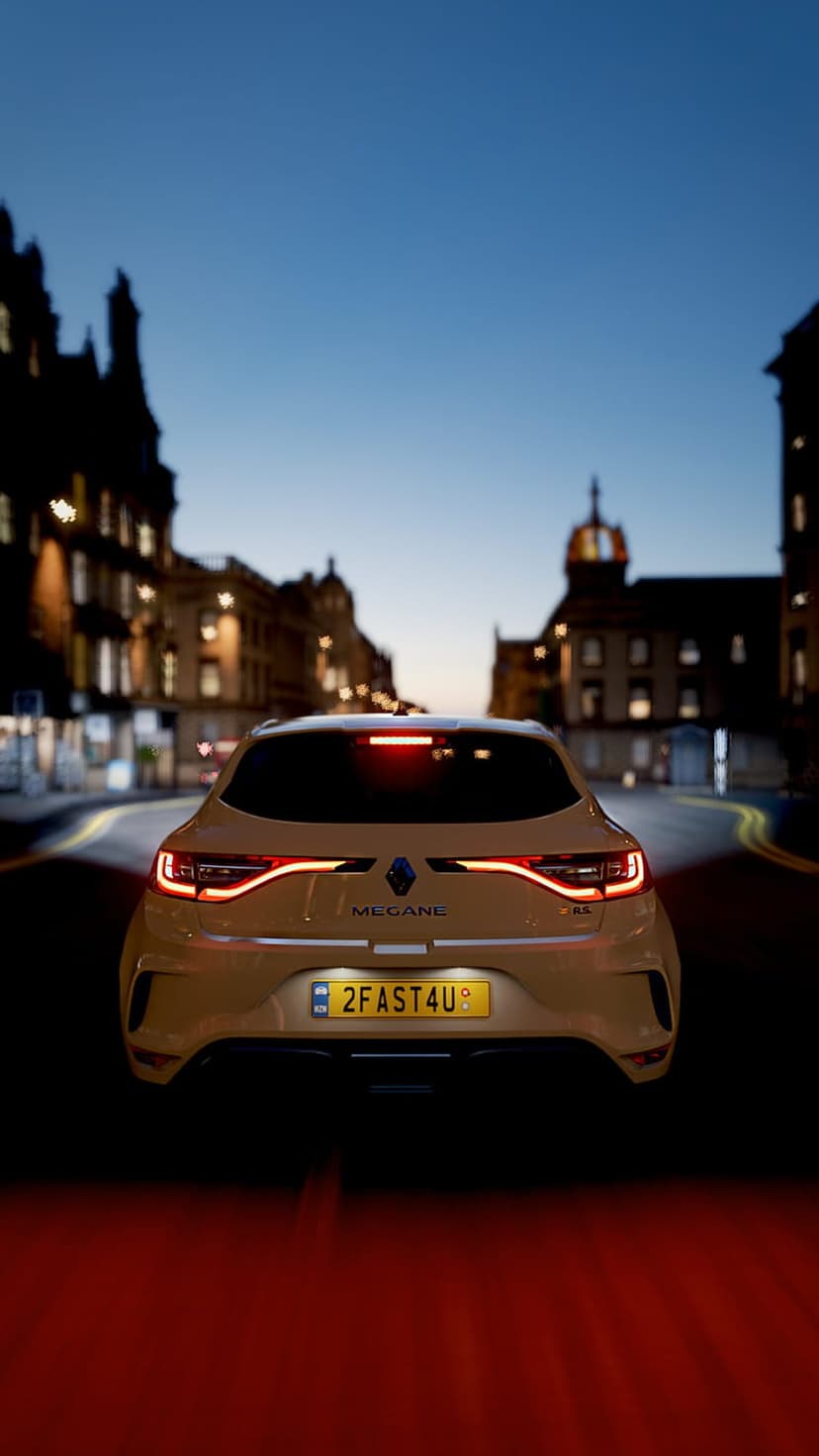 Yellow Renault Megane RS drives down a city street at night with glowing red taillights and urban building lights.