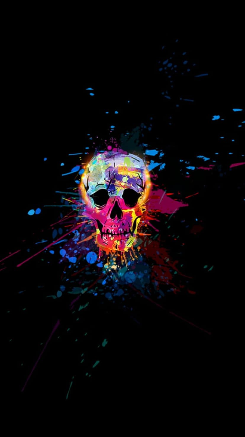 Human skull with kaleidoscopic neon paint splatters and fluorescent drips exploding against a black background.
