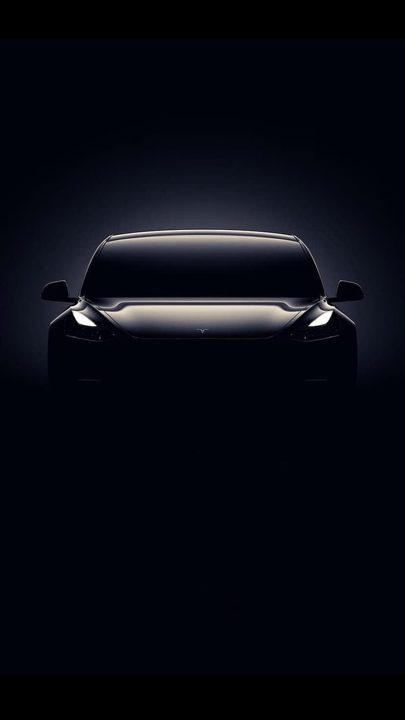 Tesla silhouette with bright LED headlights against a dark background, showcasing sleek curves and minimalist design.