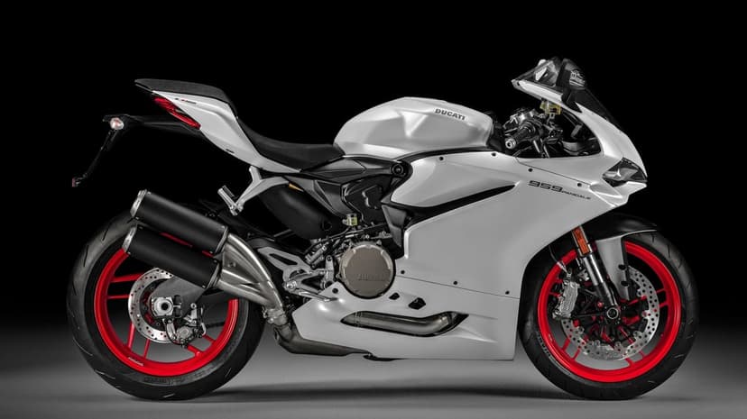 Side view of a white Ducati 959 Panigale motorcycle with red wheels against a solid black studio background.