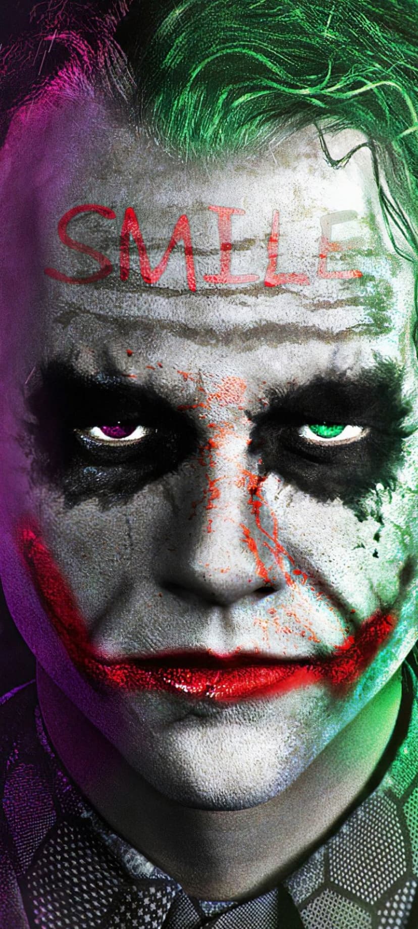 Joker’s face with white makeup, a red grin, and the word SMILE on his forehead under purple and green lighting.