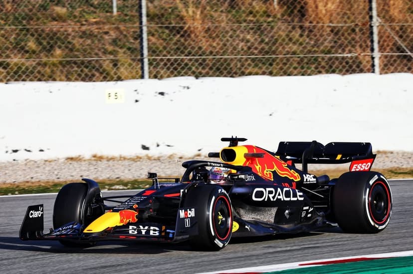 Red Bull Racing Formula 1 car with number 1 speeding on a racetrack under bright sunlight with motion blur.
