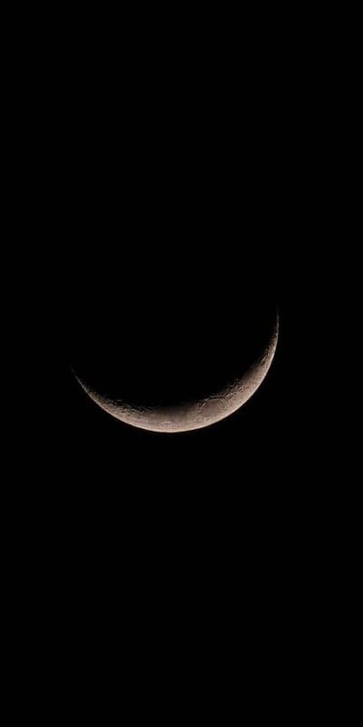 Eclipsed Smile - A Lunar Crescent Against Pure Black