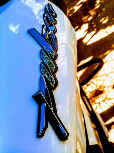 Close-up of chrome motorcycle emblem in sunlight