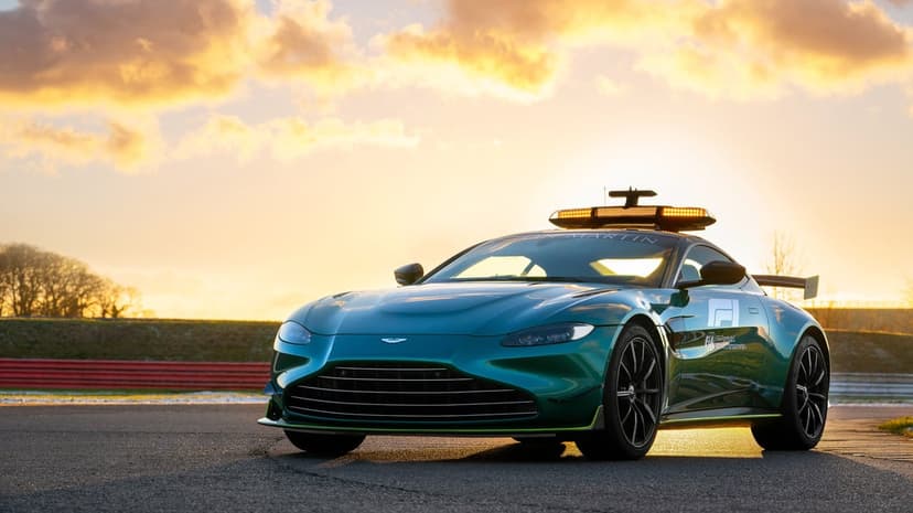 Aston Martin Vantage F1 Safety Car in racing green on a track with golden sunset clouds and warm lighting