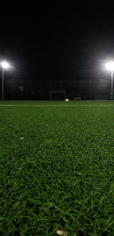 Illuminated Soccer Goal and Ball Night Field Wallpaper