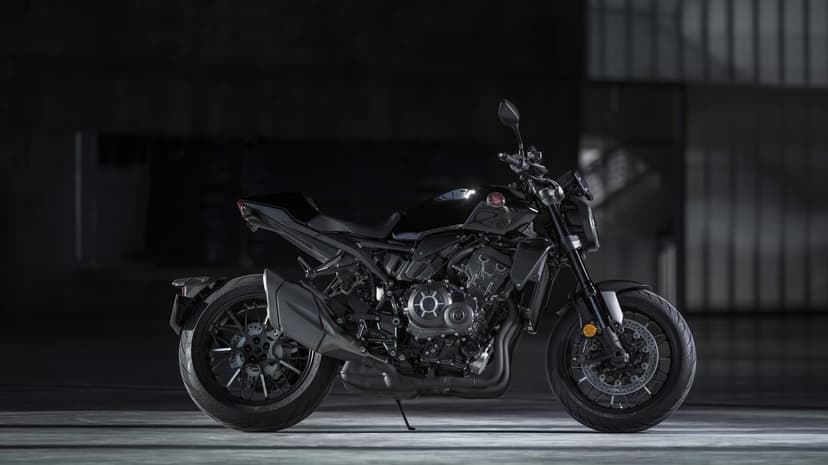 Side view of a black Honda CB1000R motorcycle in a dark studio with polished floors and moody lighting.