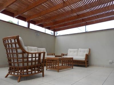 Outdoor wicker furniture under a slatted wooden patio roof