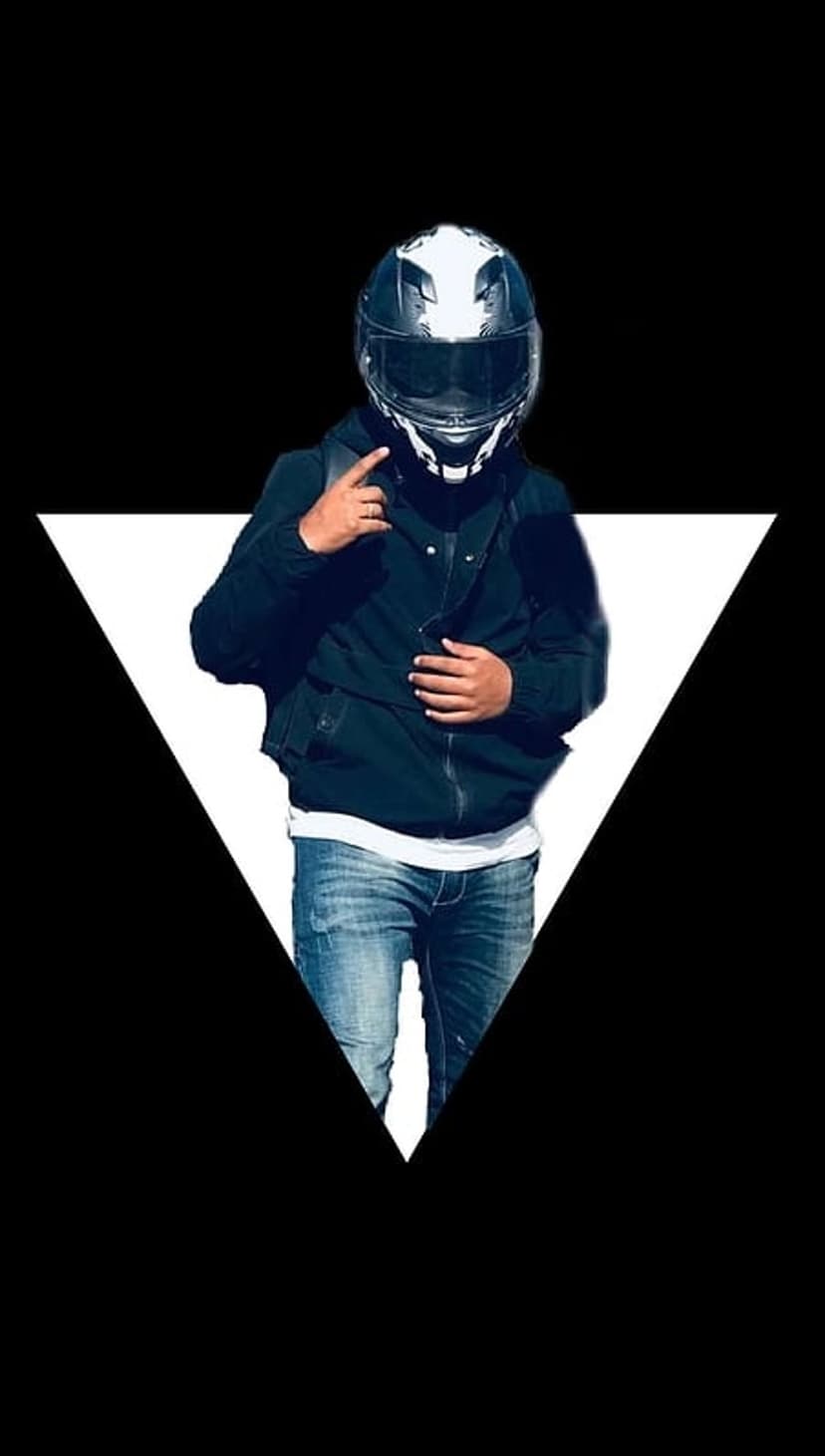Motorcyclist in a black helmet and denim jeans points forward against an inverted white triangle backdrop.