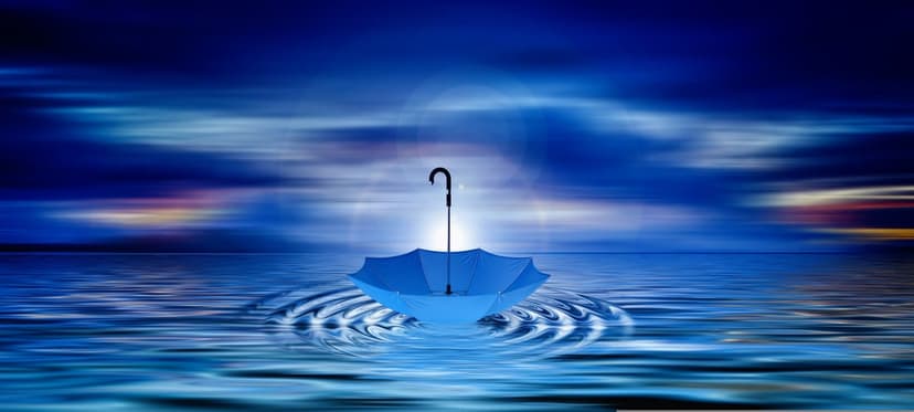 Blue umbrella floating on still water with gentle ripples under a blurred twilight sky with sunset hints.