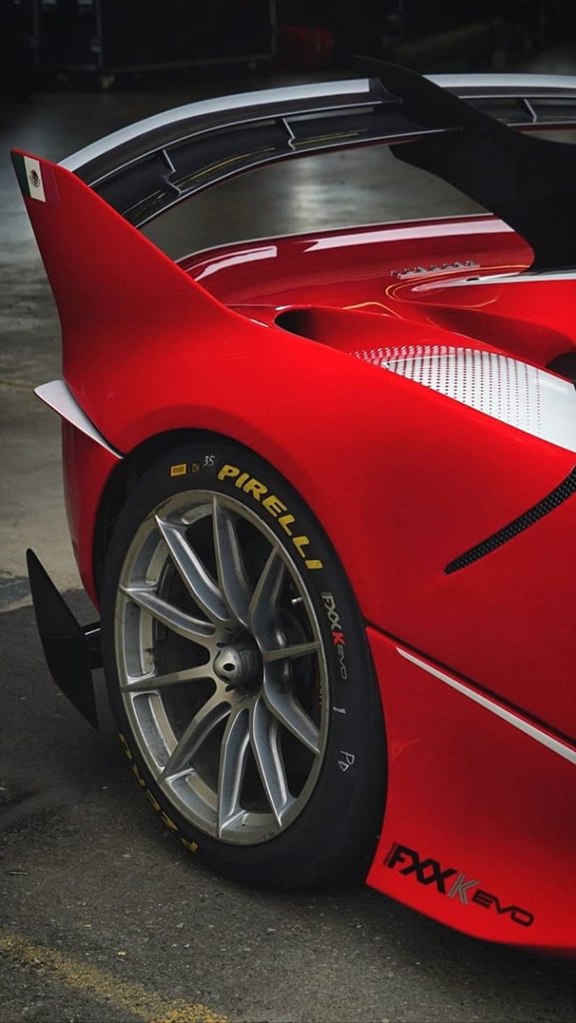 Ferrari FXX K EVO rear wheel showing Pirelli tire, alloy rim, and red aerodynamic bodywork in close-up detail.