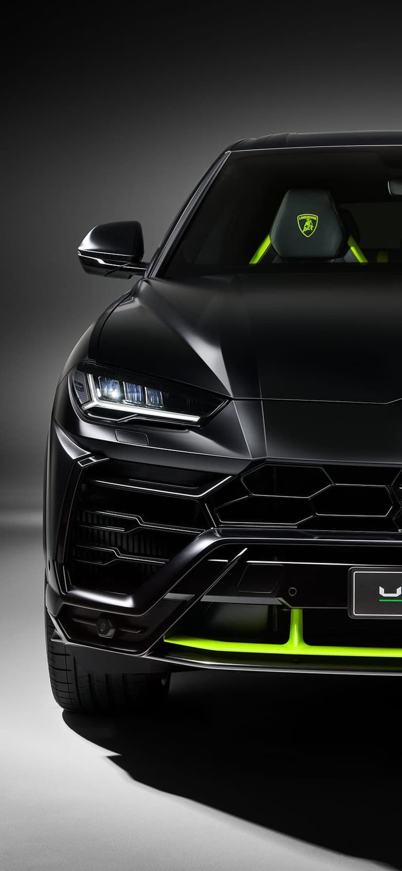 Lamborghini Urus front view with neon green splitters and LED headlights on a dark minimalist background.