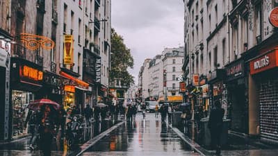 Rainy Parisian Street Scene with Shops and People