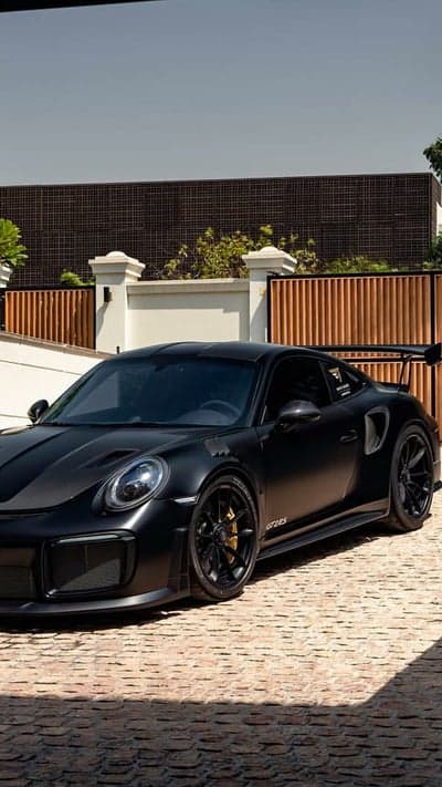 Matte Black Porsche GT2 RS parked in front of modern house