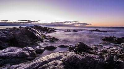 Rocky Coastline at Dusk with Purple Hues