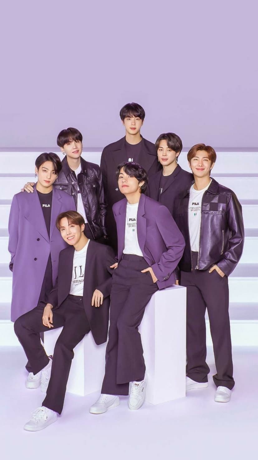 BTS members pose in purple suits and black leather jackets against a lavender backdrop for a group portrait.