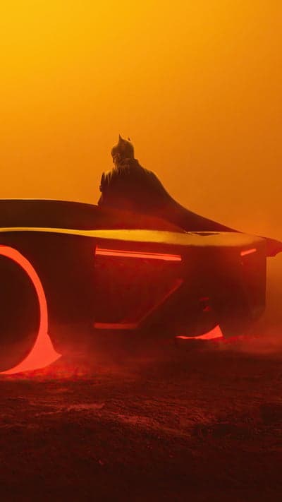 Batman in Batmobile on Orange Haze Background