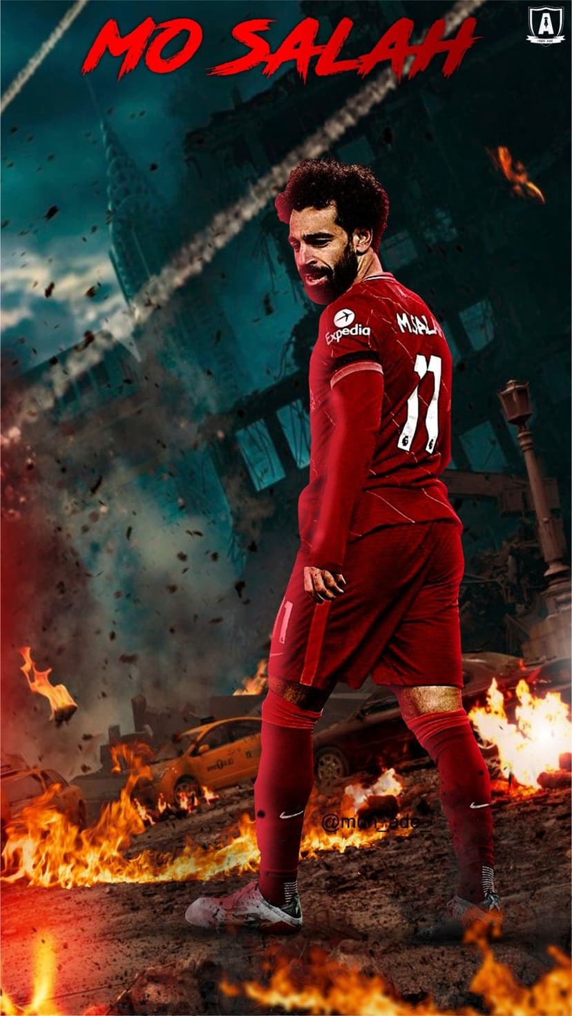Mohamed Salah in a red Liverpool kit looks over his shoulder amidst a dark city filled with fire and rubble.