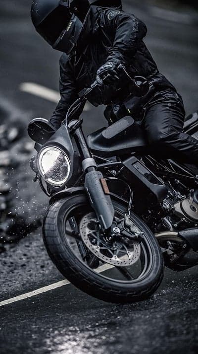 Rider in Black on Motorcycle in Rain