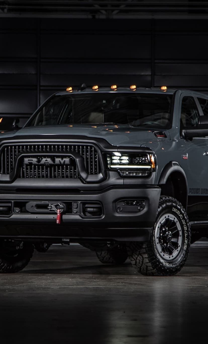Gray Ram Power Wagon truck with LED headlights and orange roof lights in a dark garage.
