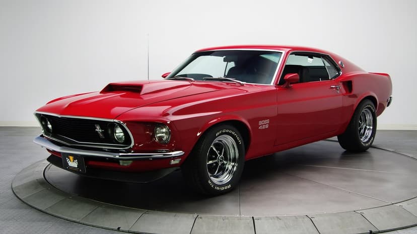 Red Ford Mustang Boss 429 classic muscle car on a circular studio platform against a white background.