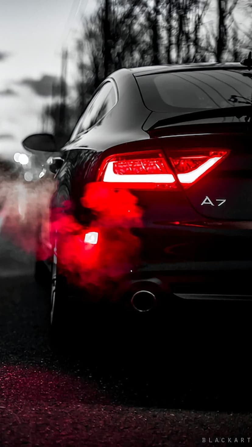 Black Audi A7 rear view with glowing red LED taillights and thick red smoke billowing from the exhaust pipes.