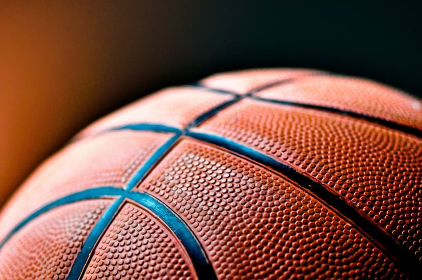 Textured orange basketball with deep blue seams highlights intricate grip patterns in a macro close-up shot.