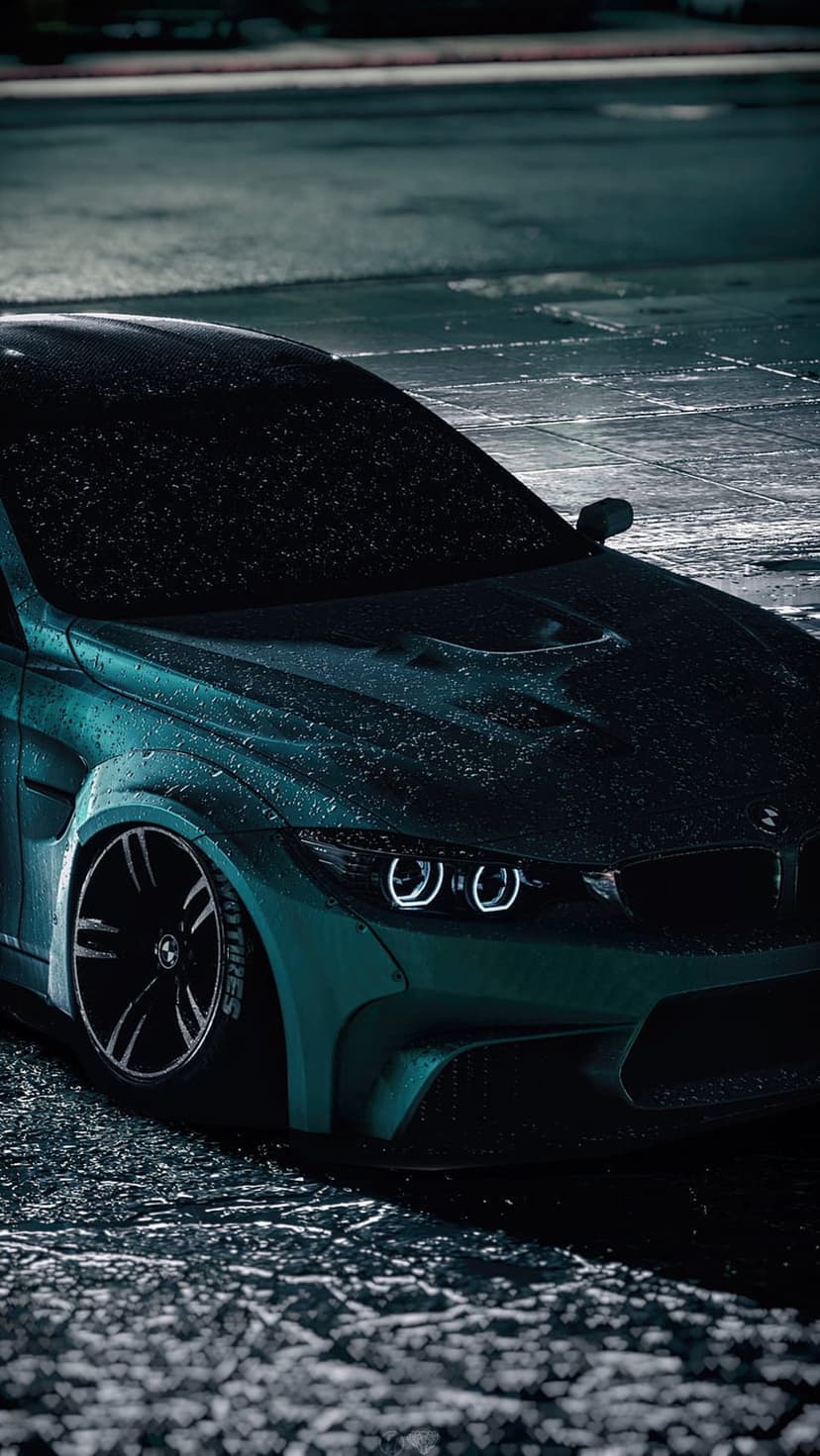 Teal BMW M3 with glowing headlights parked on wet asphalt during a rainy night under urban lighting.