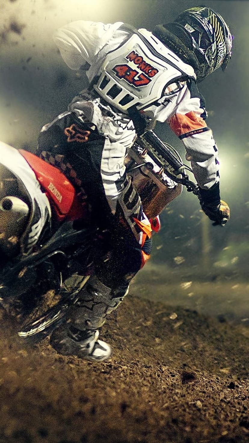 Motocross rider in orange and white gear leans a red motorcycle into a dusty turn, spraying earth into the air.
