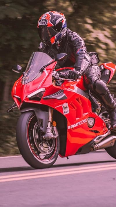 Red Ducati Motorcycle Rider Speeds Down Road