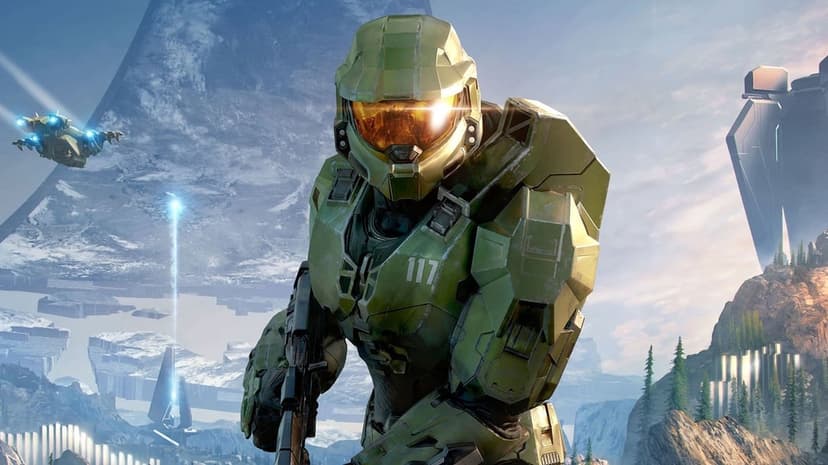Master Chief in green armor with a glowing golden visor stands against a snowy mountain backdrop on a Halo ring.