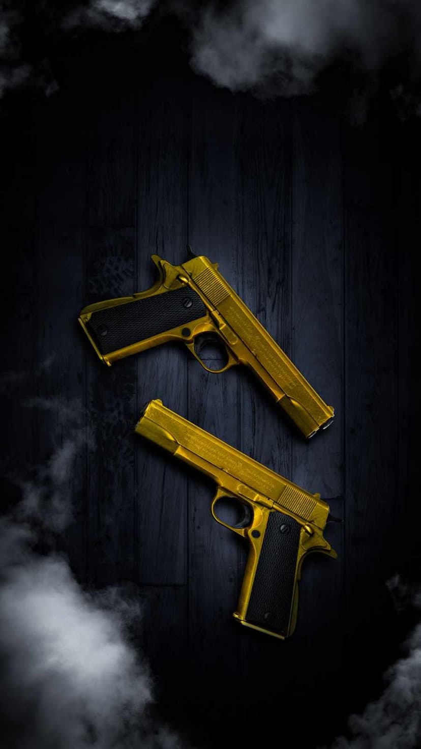 Two ornate golden handguns resting on a dark wooden table with thin wisps of white smoke curling around them.