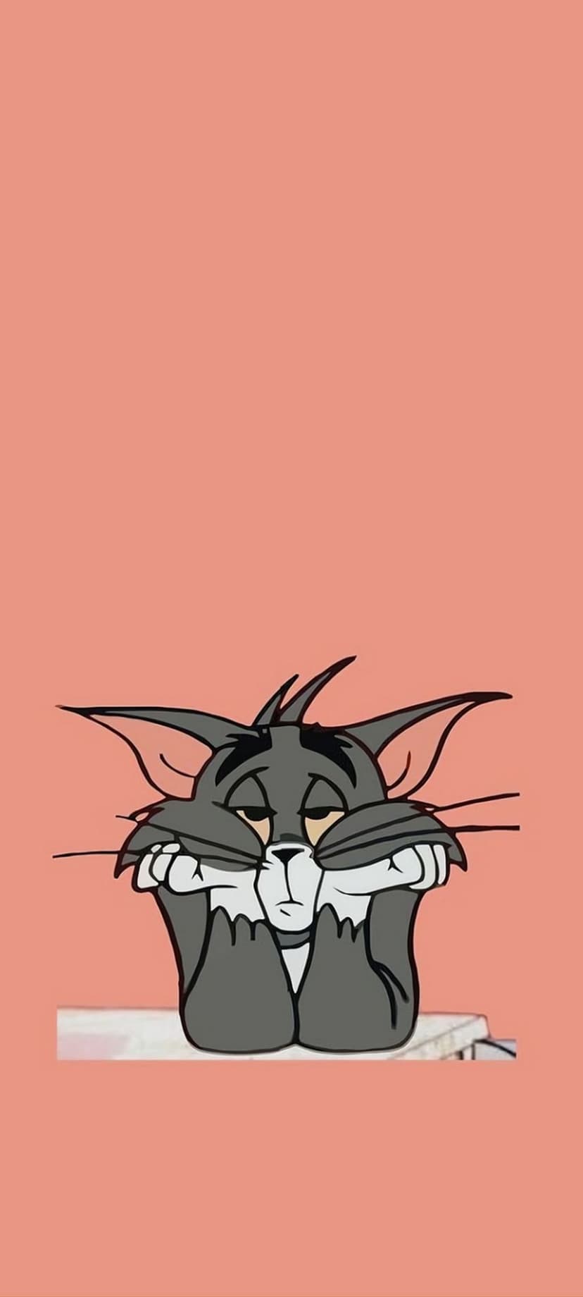 Tom the cat rests his weary face on his paws with a sad expression against a solid pastel peach background.
