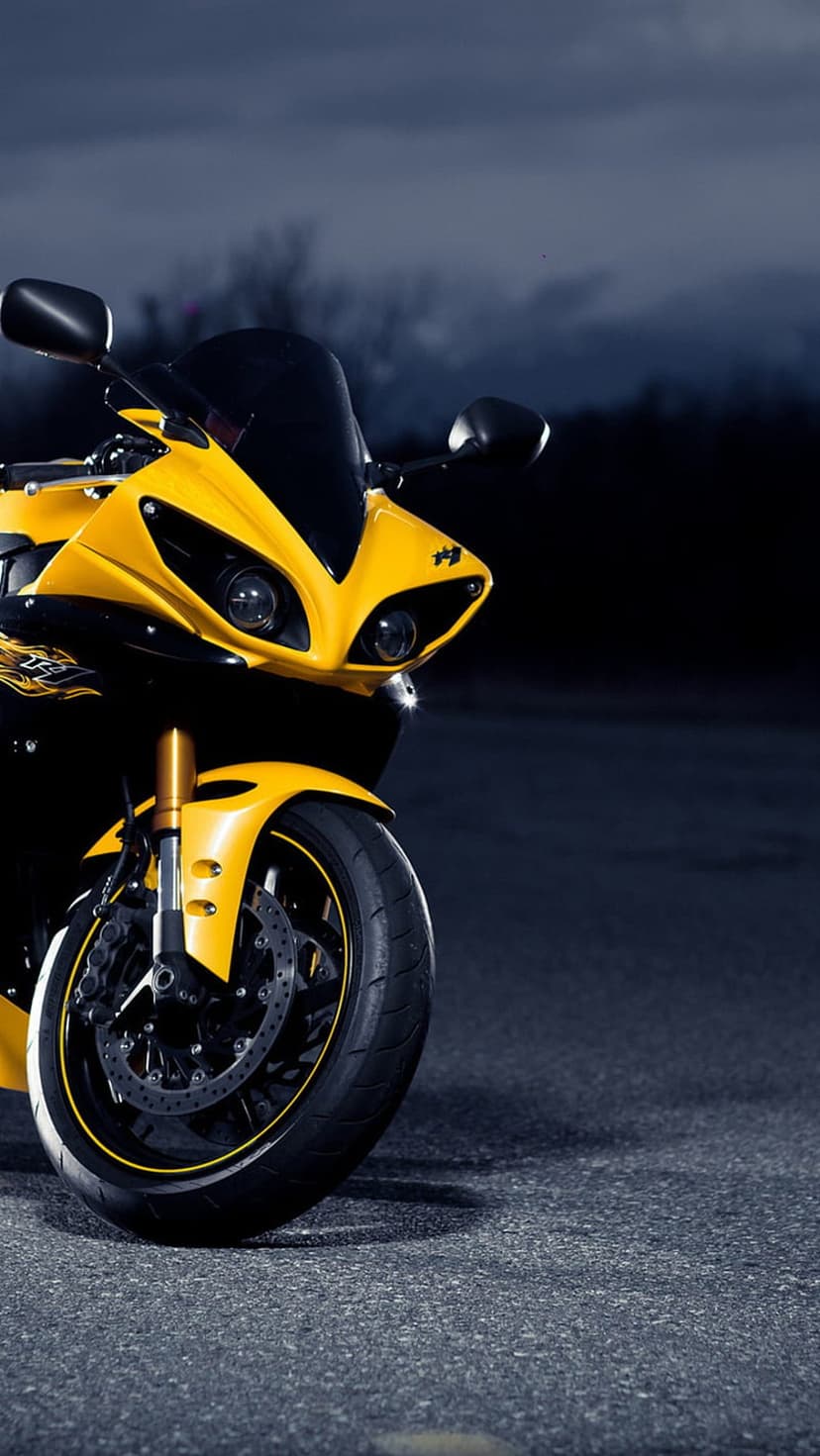 Yellow Yamaha sportbike front fairing with dual headlights and golden forks against a dark moody background.