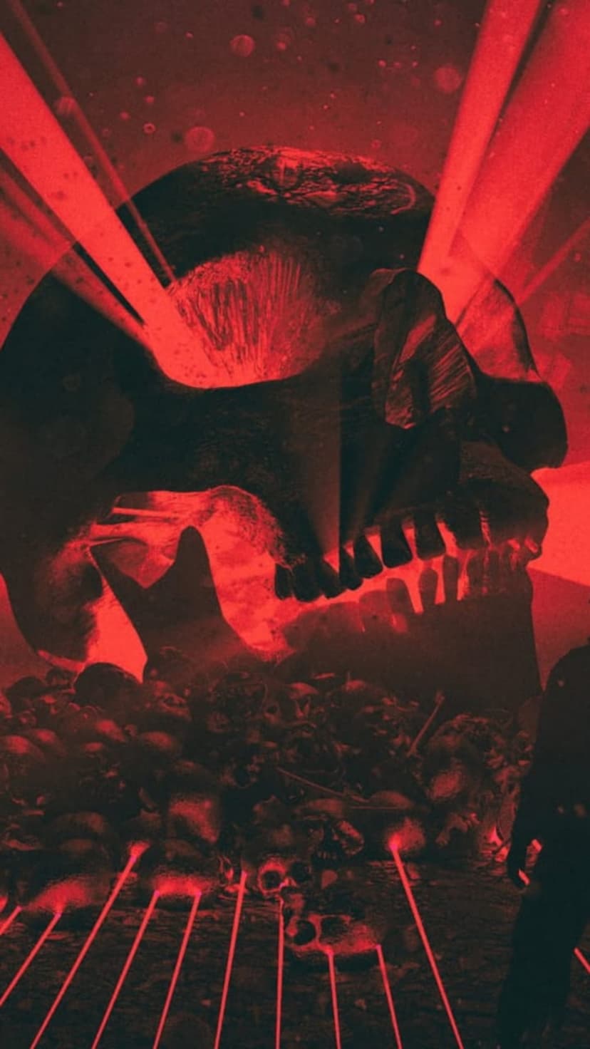 Giant skull illuminated by red laser beams overlooking a field of bones with a small silhouette standing nearby.