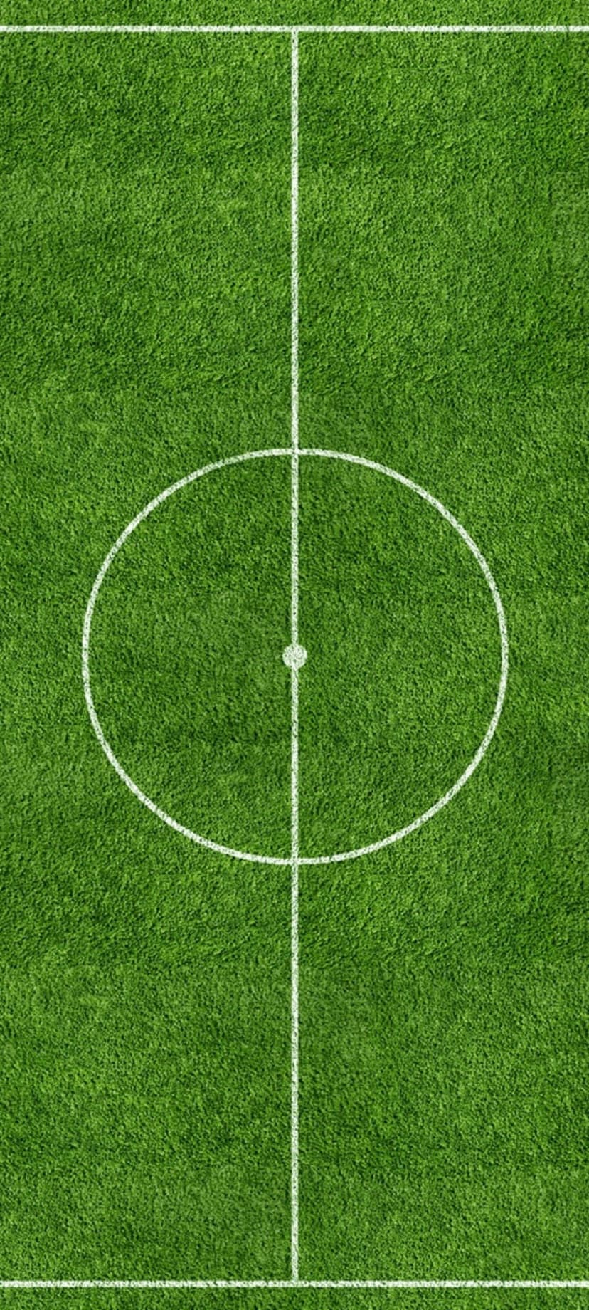 Soccer field center circle and halfway line viewed from above featuring vivid green grass and crisp white paint.
