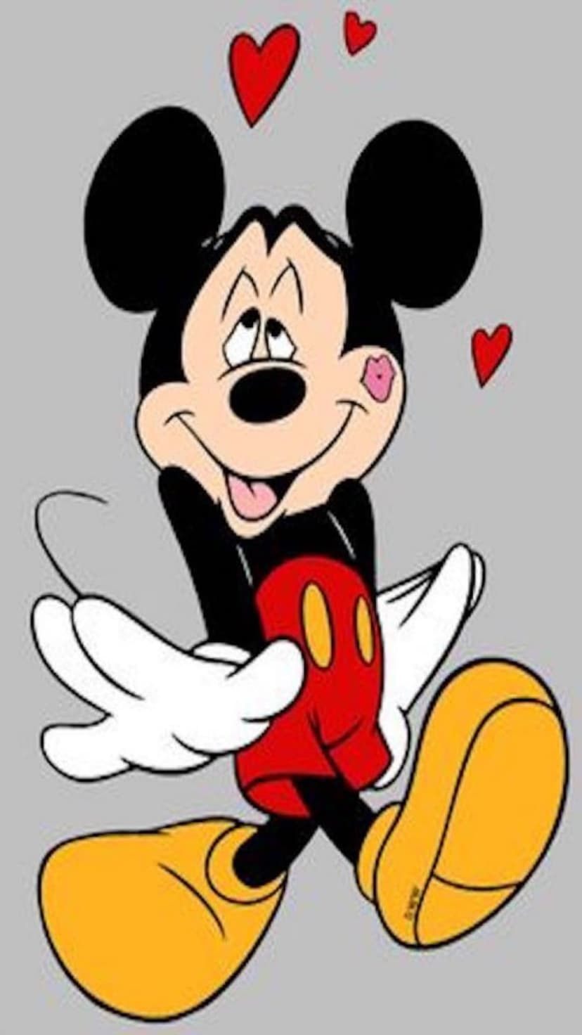 Mickey Mouse showing a pink kiss mark on his cheek surrounded by red hearts against a minimalist gray background.