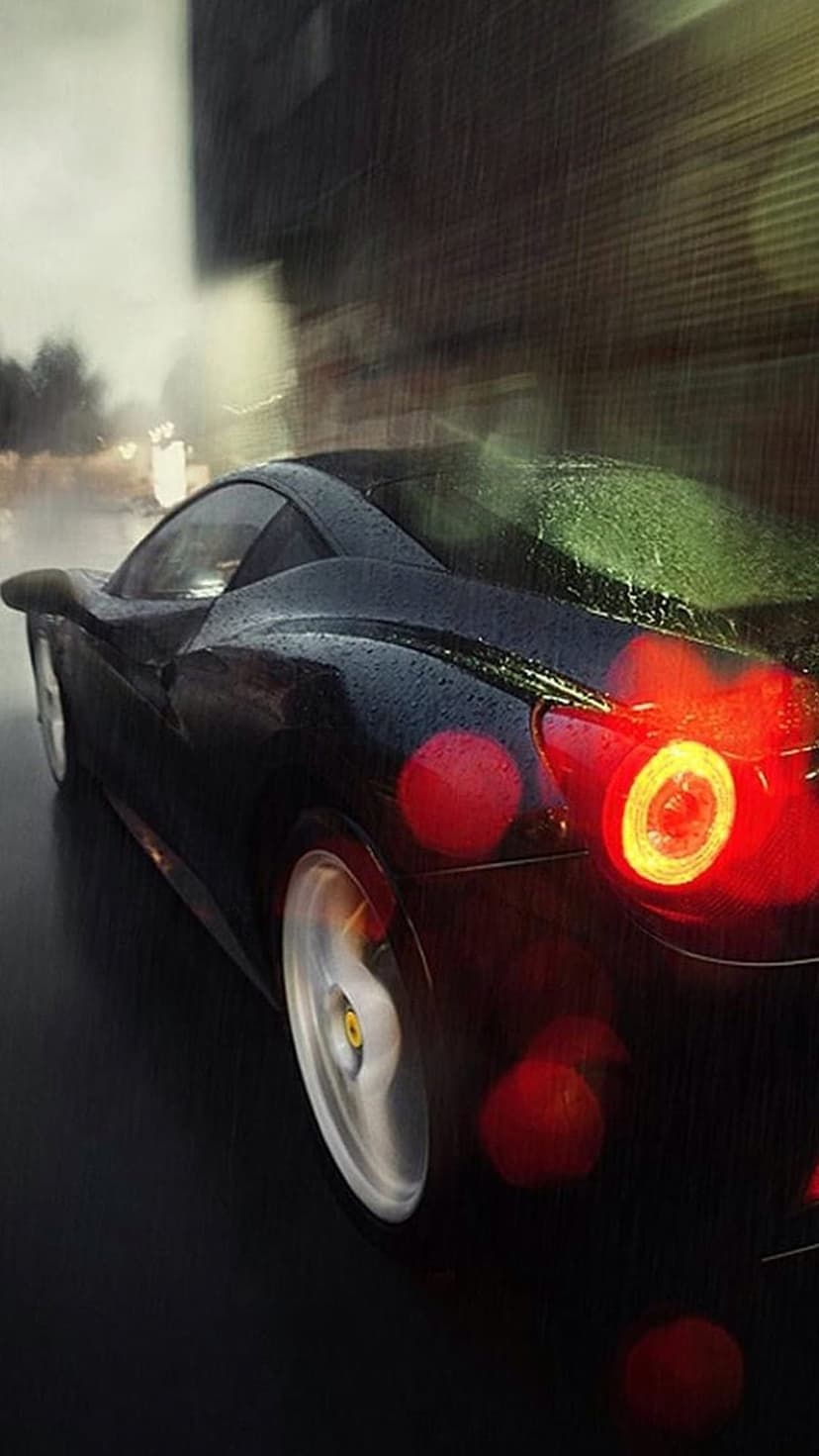 Black Ferrari rear view on wet asphalt shows glowing red taillights and rain droplets in a blurred urban setting.