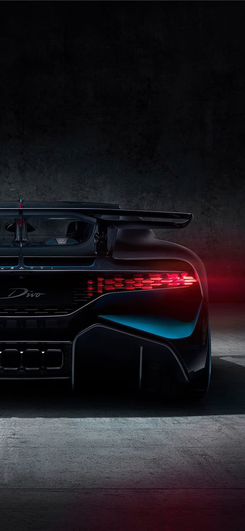 Bugatti Divo rear profile featuring red LED taillights and an aerodynamic spoiler on a dark textured background.