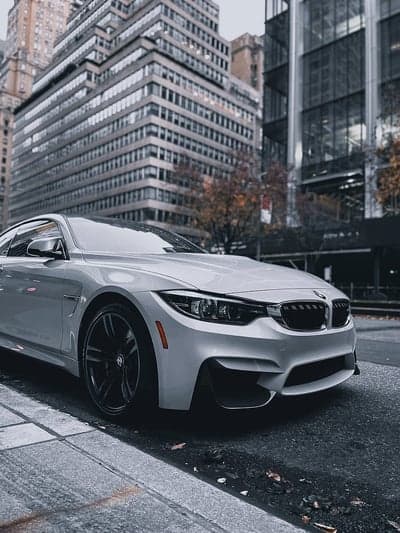 White BMW M4 Urban Street Vertical Mobile Wallpaper