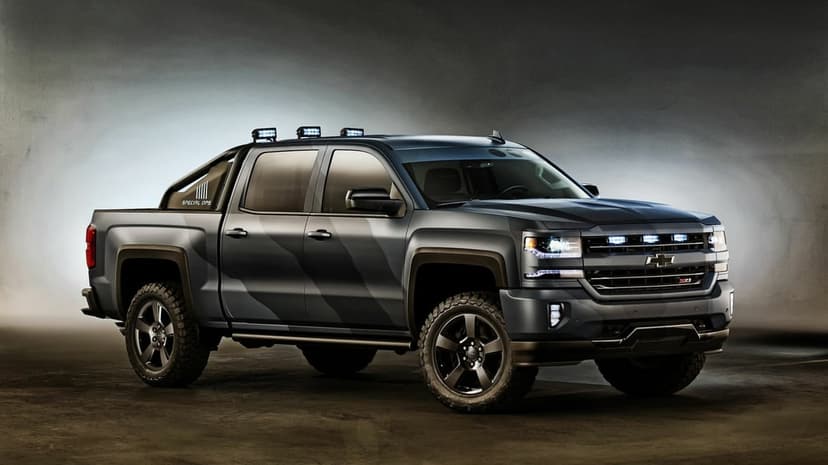 Tactical Chevrolet Silverado Special Ops pickup truck with camo paint and LED lights in a grey studio setting.