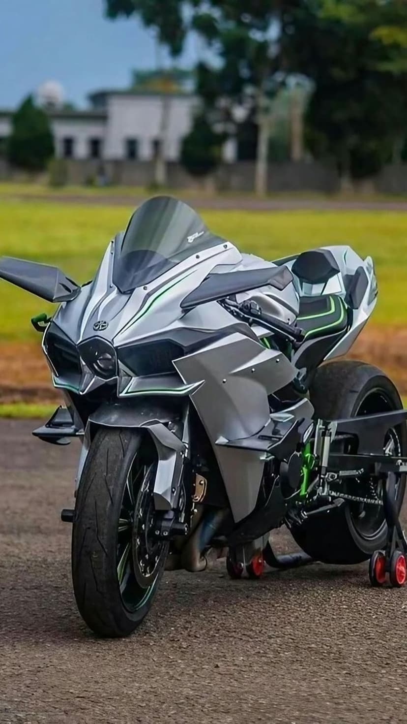 Kawasaki Ninja H2R sportbike with silver fairings and green accents rests on a stand in a vertical profile.