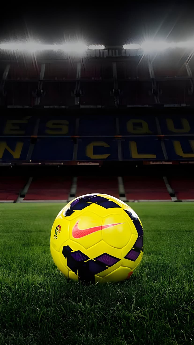Yellow and purple soccer ball on green grass with the FC Barcelona stadium seating and lights in the background.